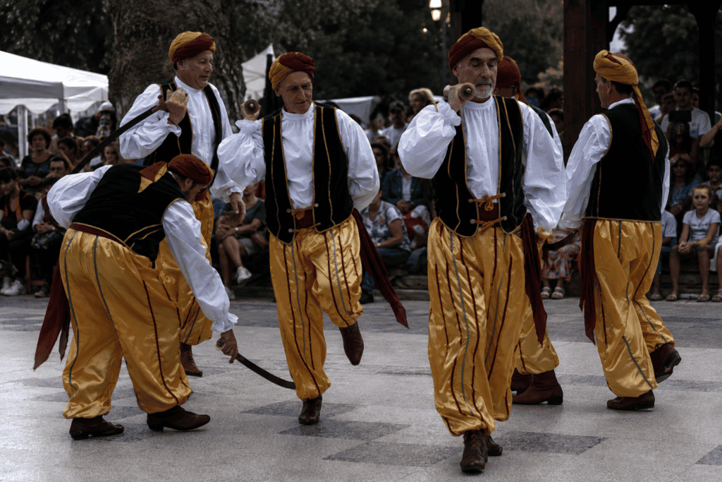 Danzatori del Bal do Sabre di Bagnasco con sciabole intrecciate nella piazza del paese, Piemonte