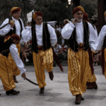 Danzatori del Bal do Sabre di Bagnasco con sciabole intrecciate nella piazza del paese, Piemonte
